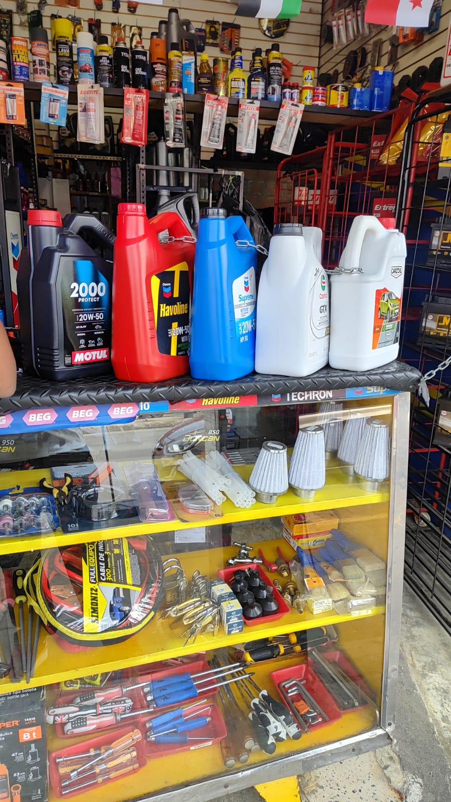 Vitrina con aceites Motul, Havoline y herramientas